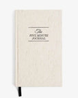 The beige hardcover Five Minute Journal by Intelligent Change features black text on the cover and a simplistic, minimalistic design. Inside, youll find 264 undated pages for six months of reflection, accompanied by a black ribbon bookmark at the bottom.