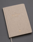 The Best Year Journal by Intelligent Change is a beige hardcover planner with gold embossed text and a white ribbon bookmark—ideal for yearly planning and intention setting.