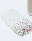The Nightside Alphabet Cascade Cotton Shade is a colorful fabric cover with scattered black, red, blue, and yellow letters on white. It lies next to a Nightside NS01 task lamp.