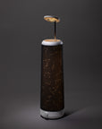 The Nightside Starlight Cotton Blackout Shade features illuminated star constellations on a cylindrical shade and stands on a white base, with a circular light source above, set against a dark background.