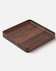 The Ugmonk Valet Tray - Medium is a square, shallow walnut tray with rounded corners and a smooth finish, precision milled to showcase its unique grain—displayed on a white background.