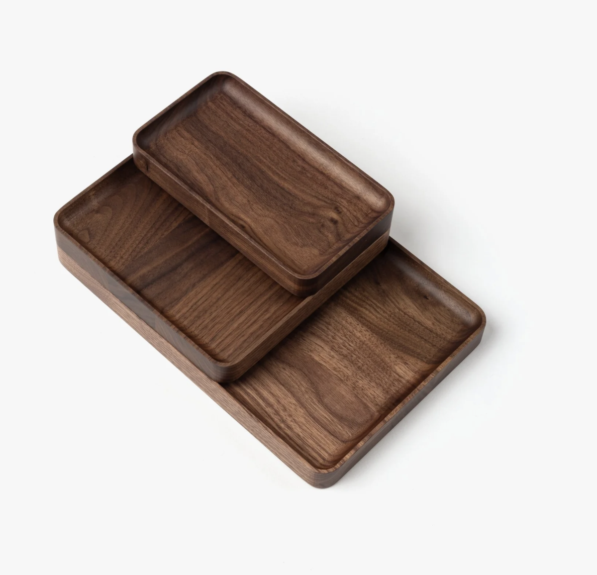 The Ugmonk Valet Tray Bundle (Walnut - Set of 3) is shown stacked together against a white background. Each handcrafted tray displays smooth, rounded edges and highlights the rich, natural walnut grain.