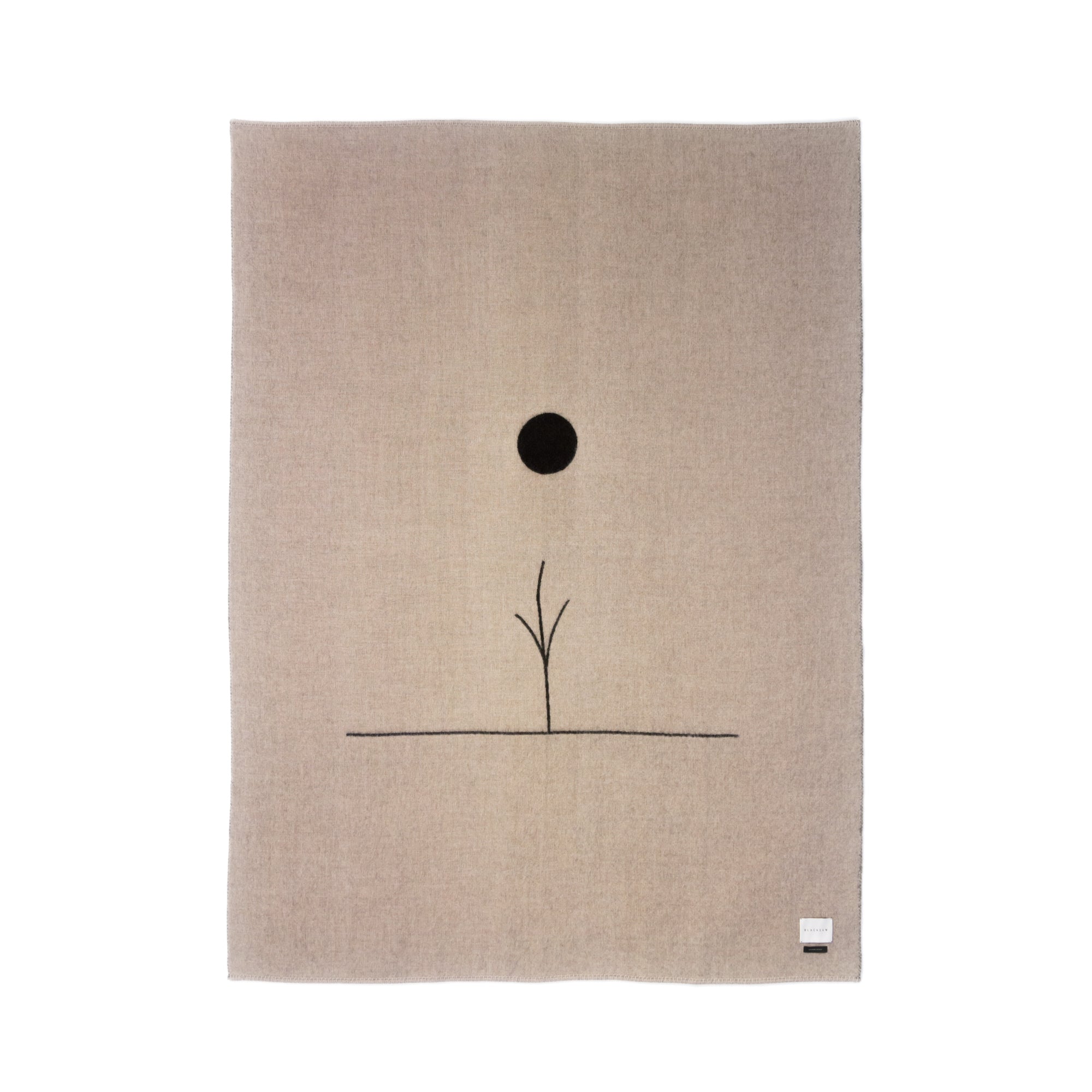 The Midnight Sun Throw Blanket by Blacksaw features a minimalist beige fabric made from eco-friendly fibers, a black vertical line with two branches below a solid black circle like a sun or moon, and includes a small white label in the bottom right corner.