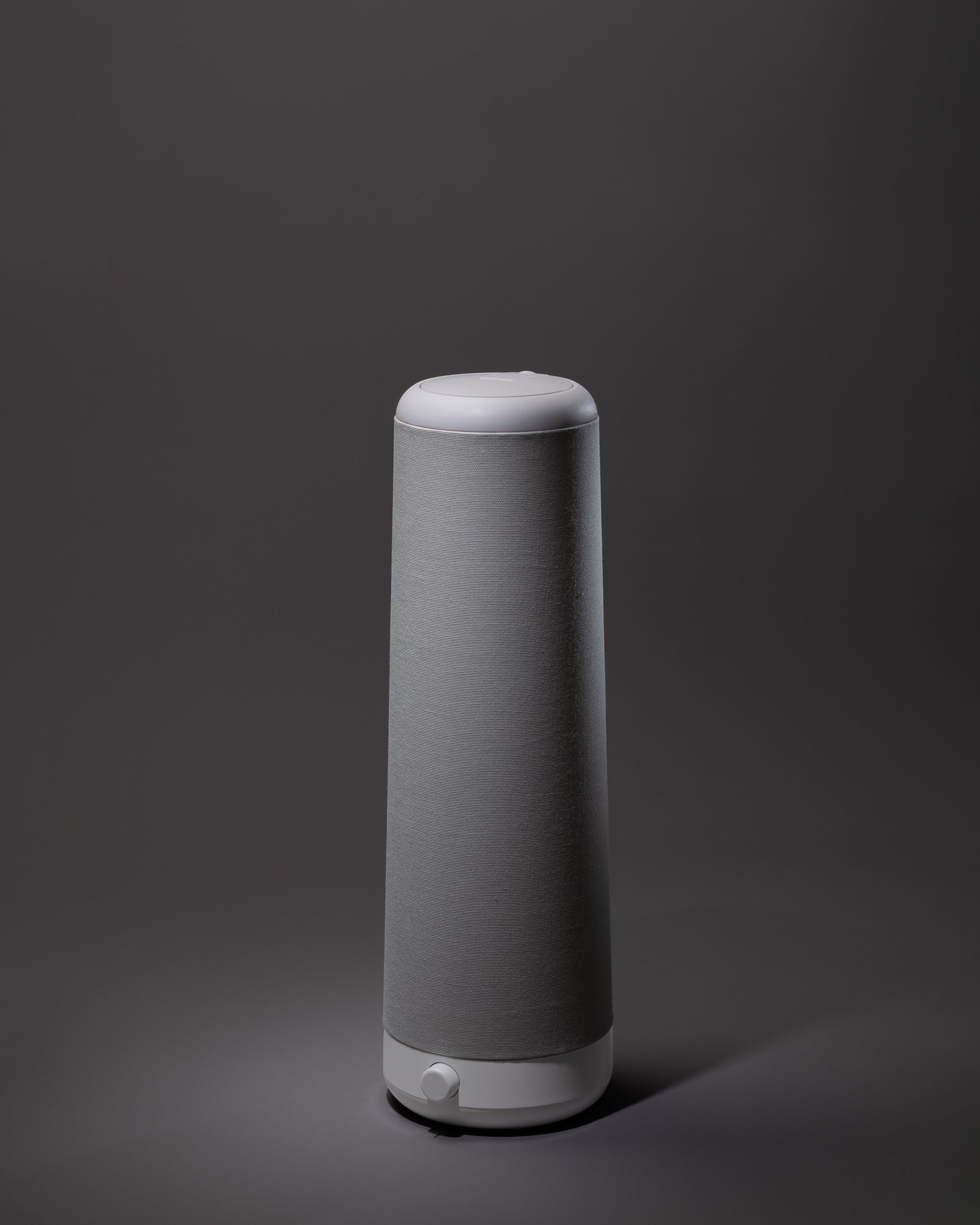 The Nightside NS01 Personal Task Lamp, a modern cylindrical lamp in grey and white with a fabric exterior and warm-white LED, sits centered against a plain dark background.