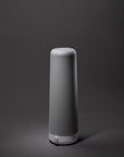 The Nightside NS01 Personal Task Lamp, a modern cylindrical lamp in grey and white with a fabric exterior and warm-white LED, sits centered against a plain dark background.