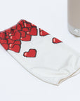 The 8-bit Hearts Cotton Shade, featuring red pixelated heart designs on white fabric, is displayed on a white surface next to the light beige base of a Nightside NS01 task lamp, awaiting its interchangeable shade.