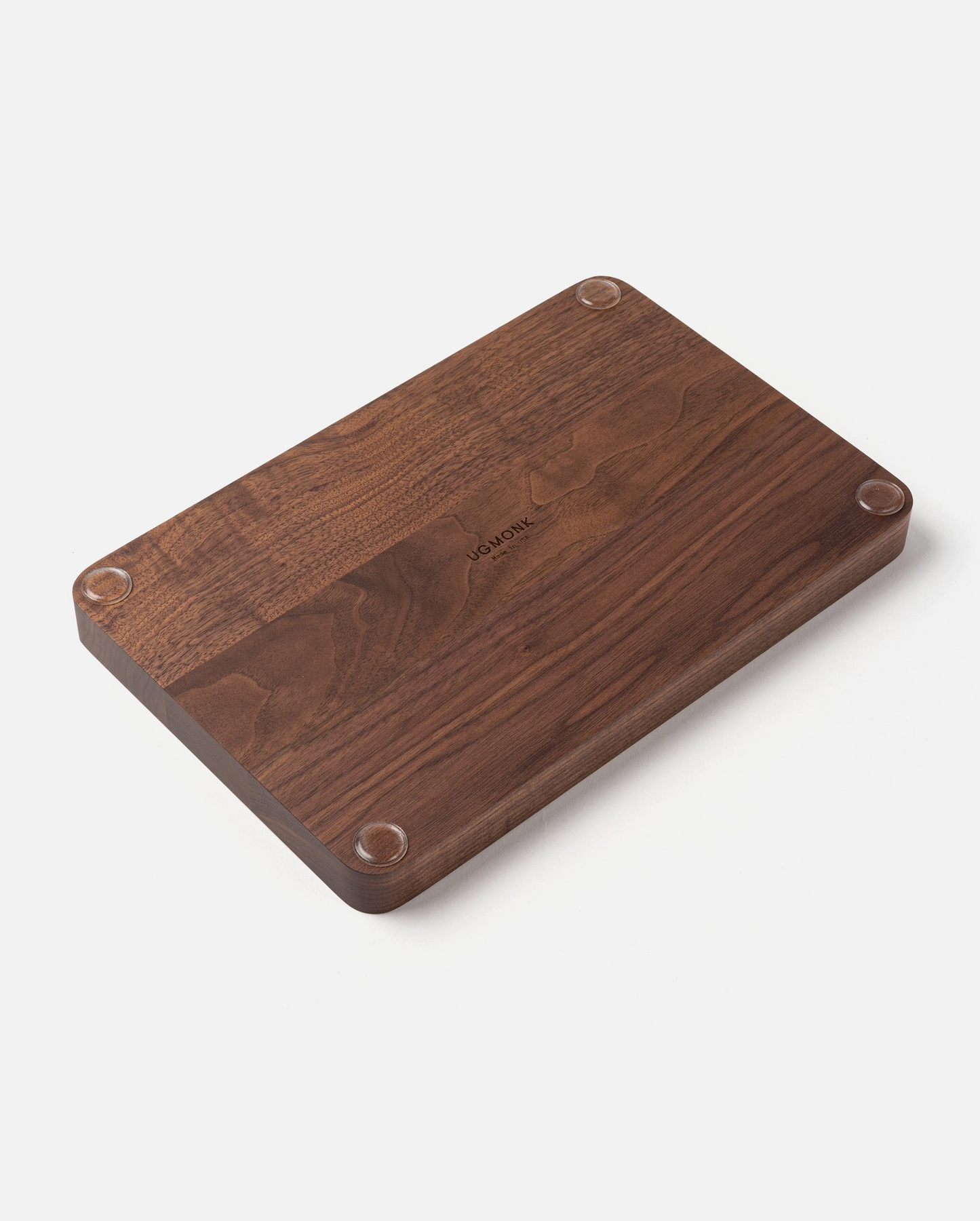 The Ugmonk Valet Tray - Large features a rectangular dark wood design with a matte finish, rounded edges, four small circular feet at each corner, and a subtle engraved logo in the center, shown against a white background.