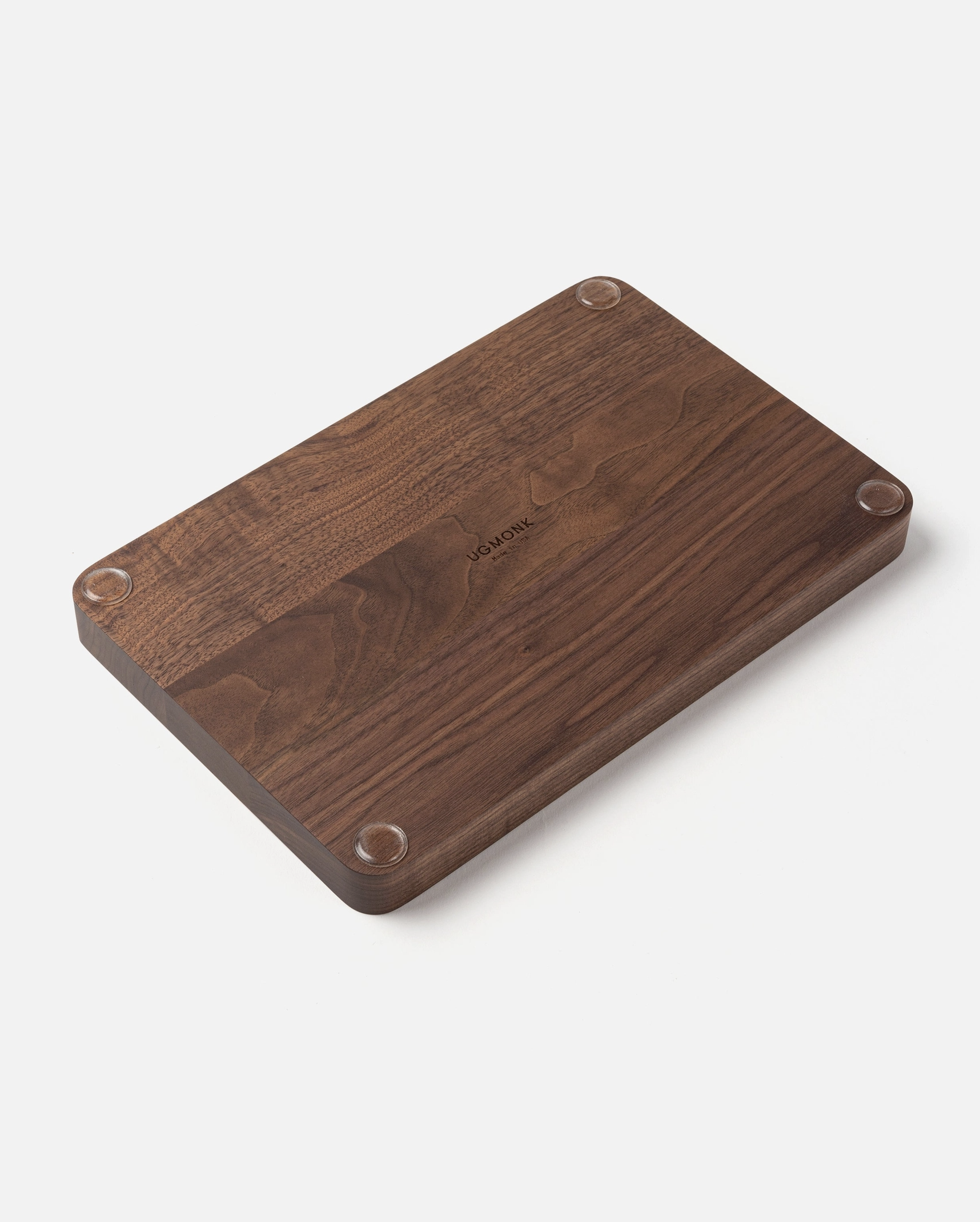 The Ugmonk Valet Tray - Large features a rectangular dark wood design with a matte finish, rounded edges, four small circular feet at each corner, and a subtle engraved logo in the center, shown against a white background.