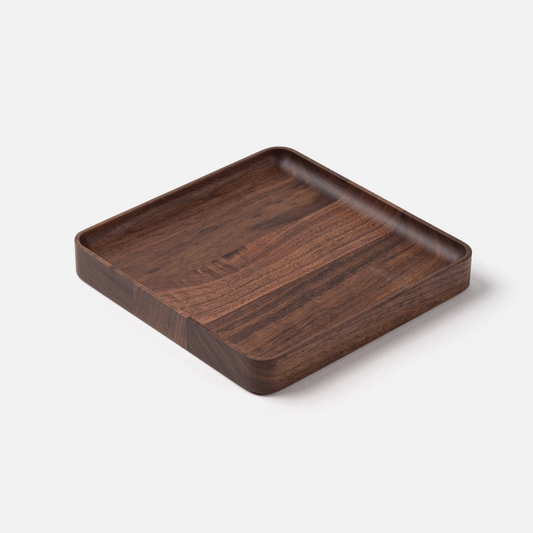 The Ugmonk Valet Tray - Medium is a square, shallow walnut tray with rounded corners and a smooth finish, precision milled to showcase its unique grain—displayed on a white background.