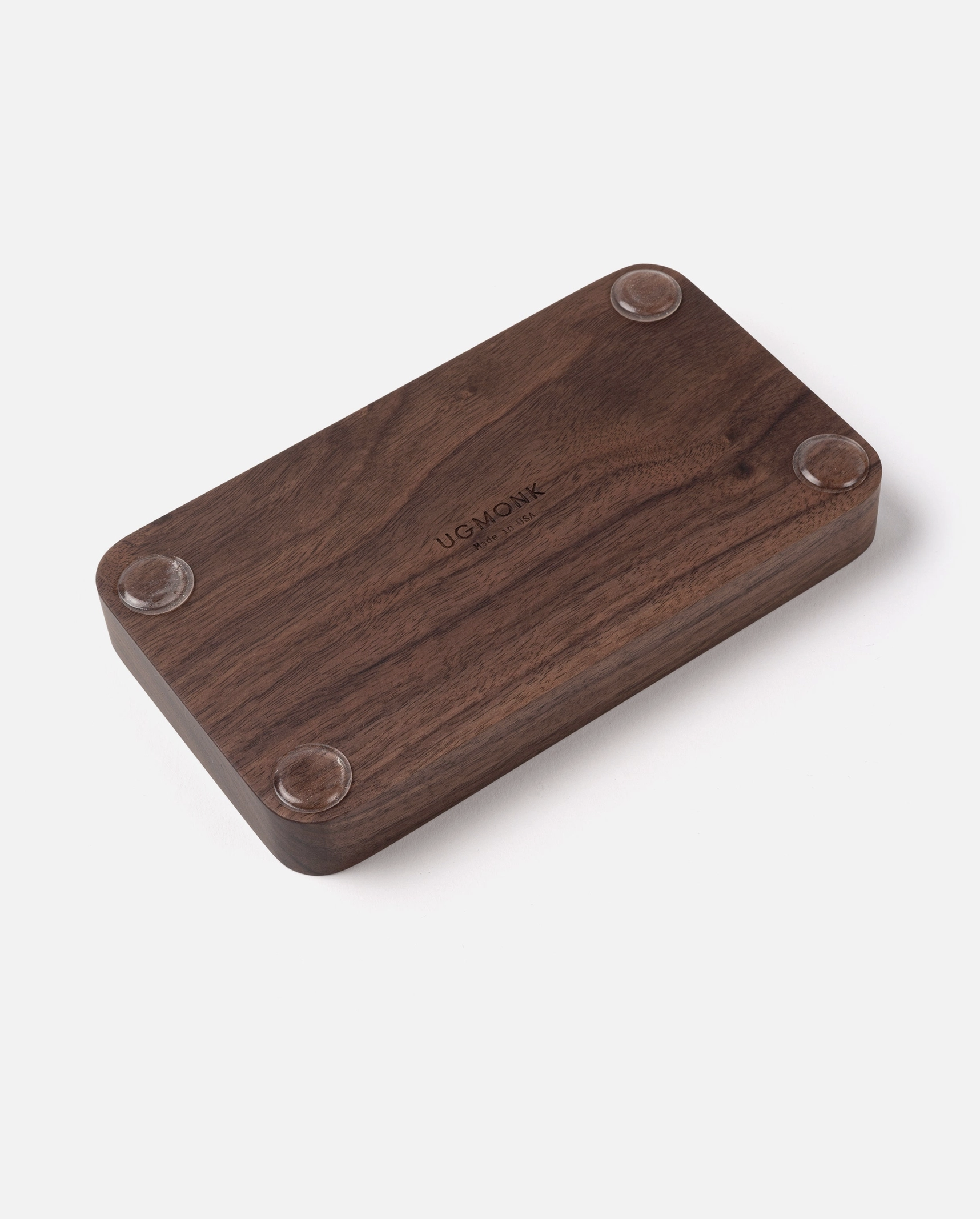 The Ugmonk Valet Tray - Small is a handcrafted, solid walnut rectangular tray with rounded corners, four circular rubber feet, Ugmonk engraved at the center, and a rich dark brown wood grain.