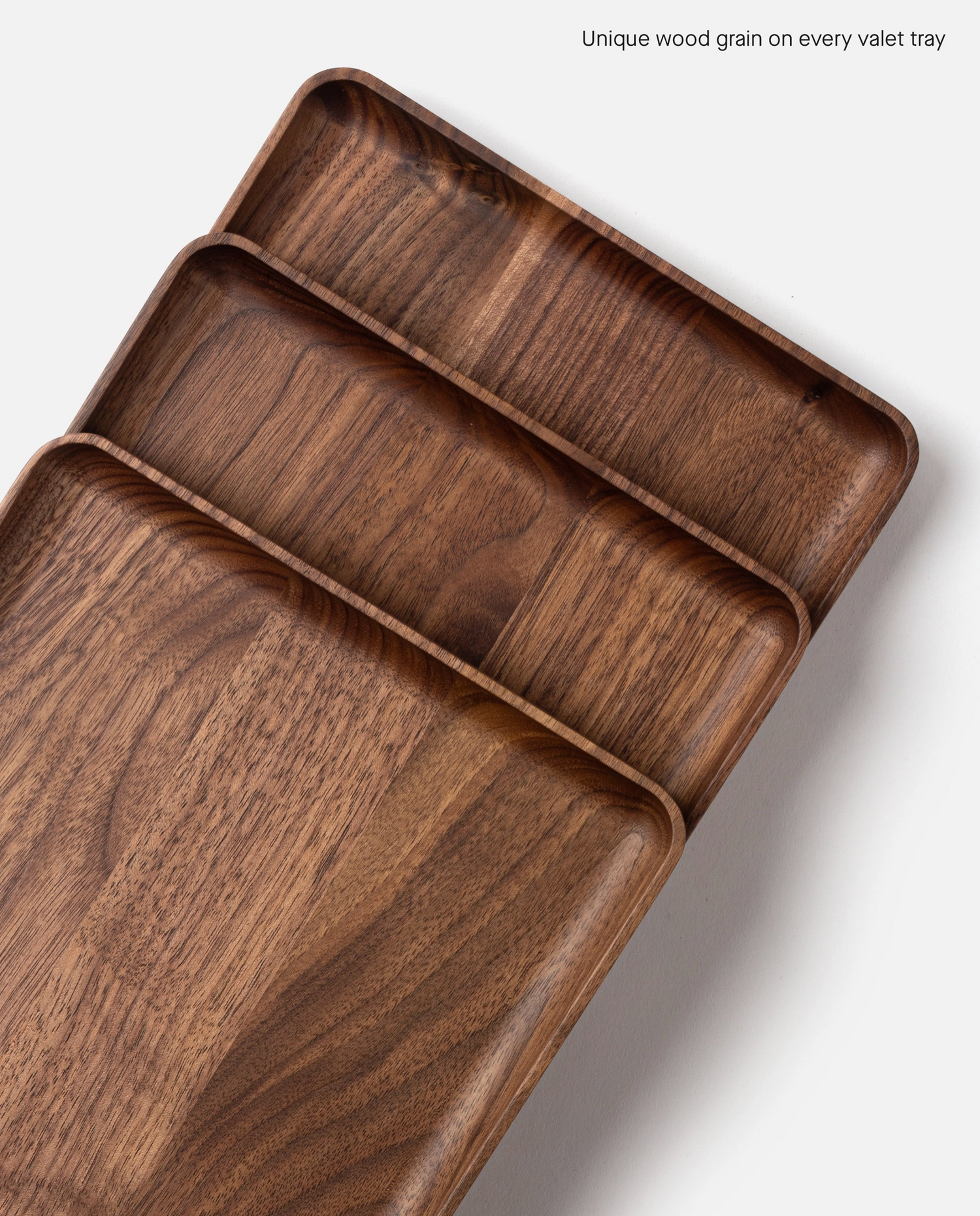 The Ugmonk Valet Tray - Large features unique natural walnut wood grain and a smooth matte finish, shown on a white background. Text in the upper right reads: Unique wood grain on every valet tray.