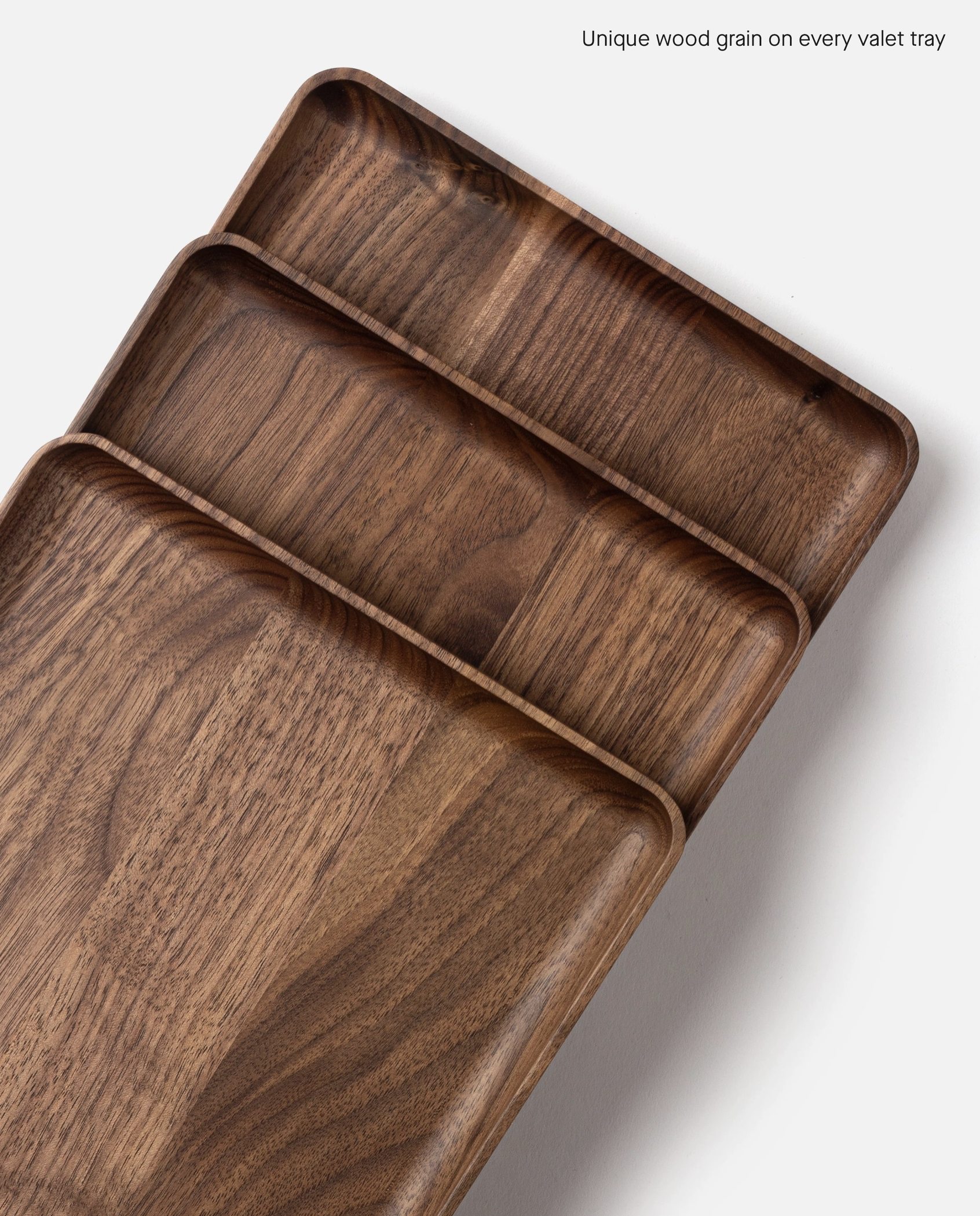 The Ugmonk Valet Tray - Large features unique natural walnut wood grain and a smooth matte finish, shown on a white background. Text in the upper right reads: Unique wood grain on every valet tray.